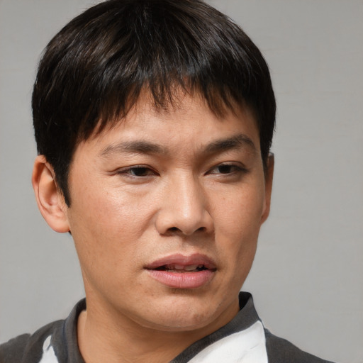 Joyful asian young-adult male with short  brown hair and brown eyes