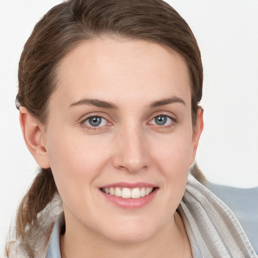 Joyful white young-adult female with medium  brown hair and grey eyes