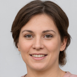 Joyful white young-adult female with medium  brown hair and grey eyes