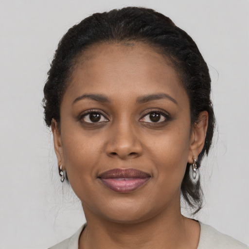 Joyful black young-adult female with long  brown hair and brown eyes
