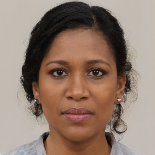 Joyful black young-adult female with medium  brown hair and brown eyes