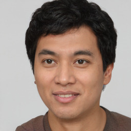 Joyful asian young-adult male with short  brown hair and brown eyes