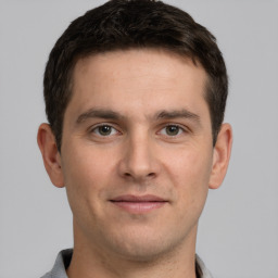 Joyful white young-adult male with short  brown hair and grey eyes