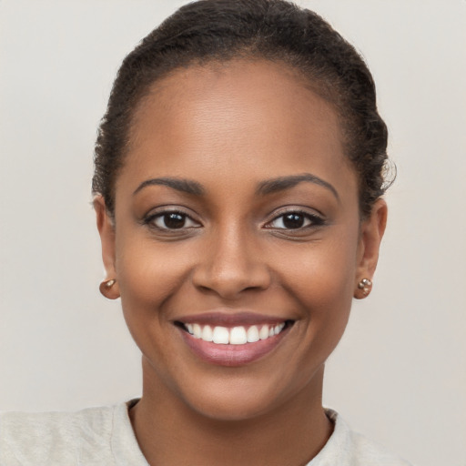 Joyful black young-adult female with short  brown hair and brown eyes