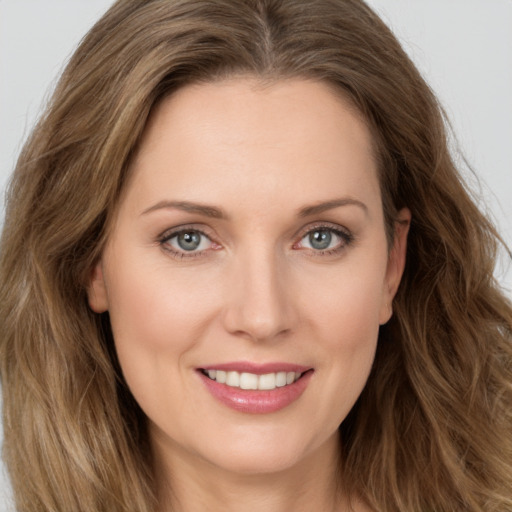 Joyful white young-adult female with long  brown hair and green eyes