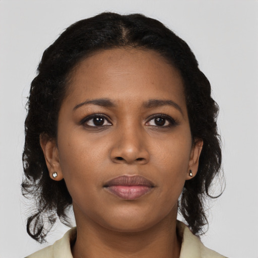 Joyful black young-adult female with long  brown hair and brown eyes
