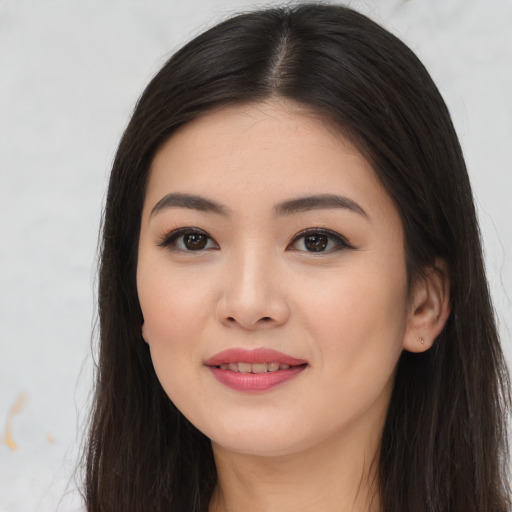 Joyful asian young-adult female with long  brown hair and brown eyes