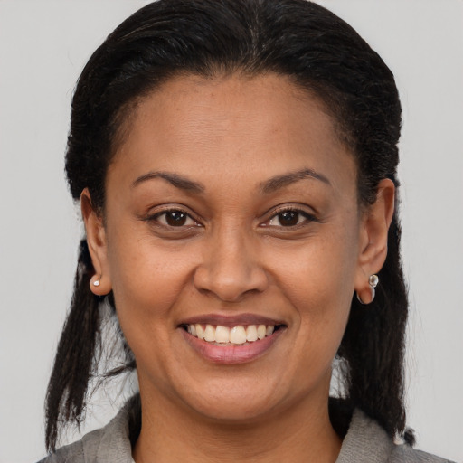 Joyful latino adult female with medium  brown hair and brown eyes