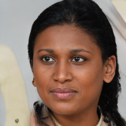 Joyful black young-adult female with medium  brown hair and brown eyes