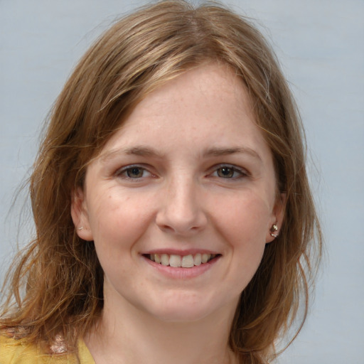 Joyful white young-adult female with medium  brown hair and grey eyes