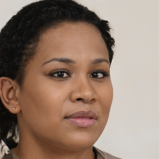 Joyful black young-adult female with long  brown hair and brown eyes