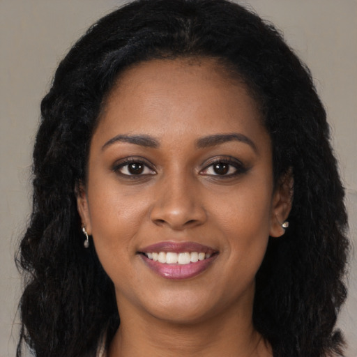 Joyful black young-adult female with long  black hair and brown eyes