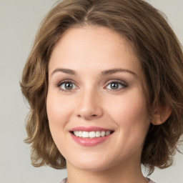 Joyful white young-adult female with medium  brown hair and green eyes