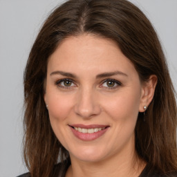 Joyful white young-adult female with long  brown hair and brown eyes