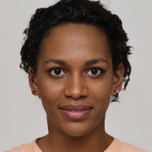 Joyful black young-adult female with short  black hair and brown eyes