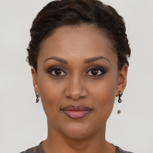 Joyful black young-adult female with short  brown hair and brown eyes