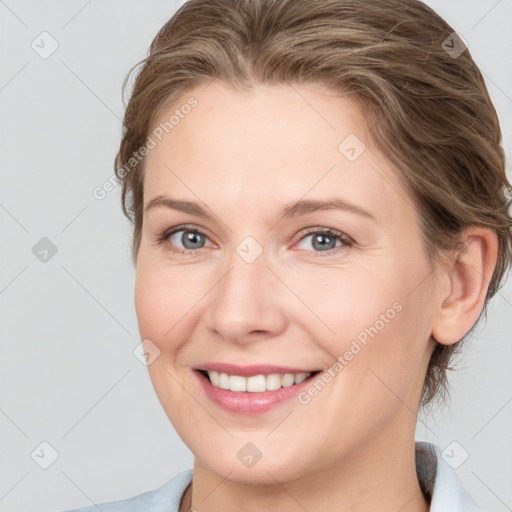 Joyful white young-adult female with medium  brown hair and grey eyes