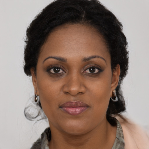 Joyful black young-adult female with long  brown hair and brown eyes