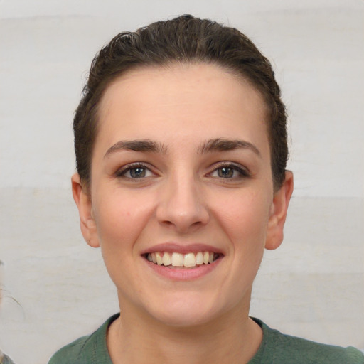 Joyful white young-adult female with short  brown hair and brown eyes