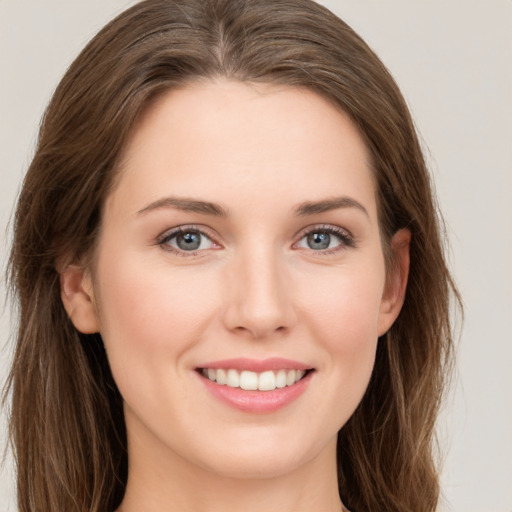 Joyful white young-adult female with long  brown hair and green eyes