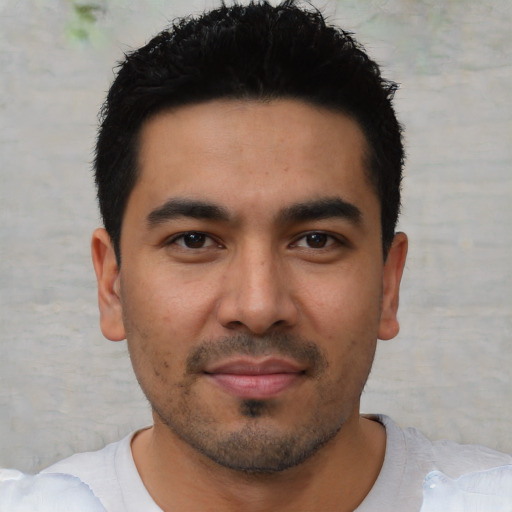 Joyful latino young-adult male with short  black hair and brown eyes