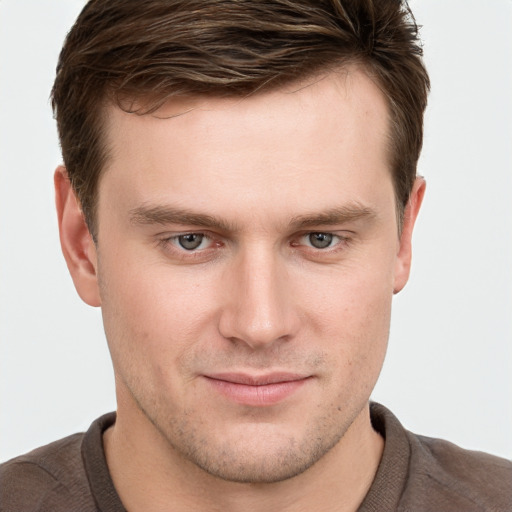 Joyful white young-adult male with short  brown hair and grey eyes