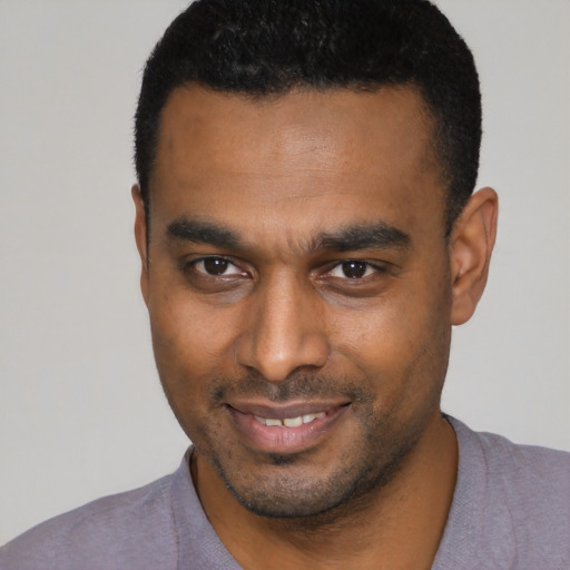 Joyful black young-adult male with short  black hair and brown eyes