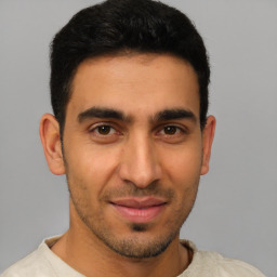 Joyful latino young-adult male with short  brown hair and brown eyes