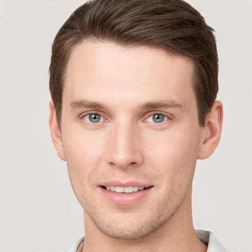 Joyful white young-adult male with short  brown hair and grey eyes