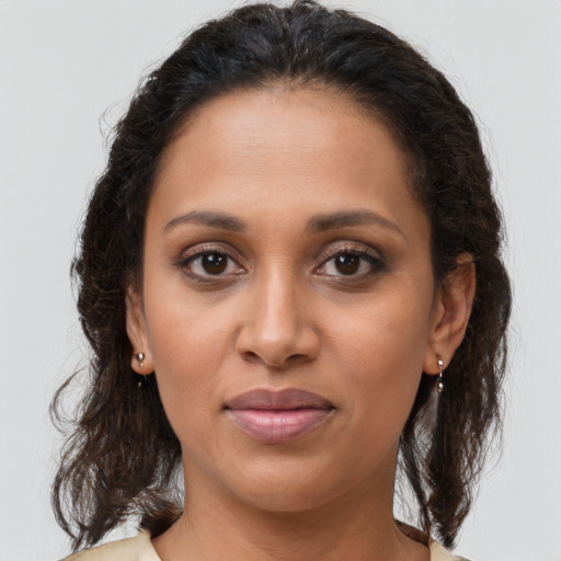Joyful latino adult female with medium  brown hair and brown eyes