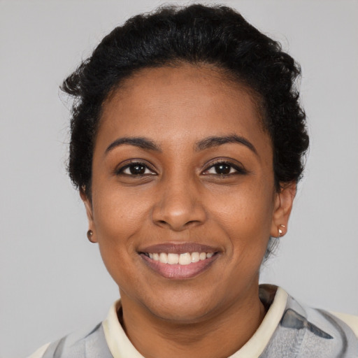 Joyful black young-adult female with short  brown hair and brown eyes