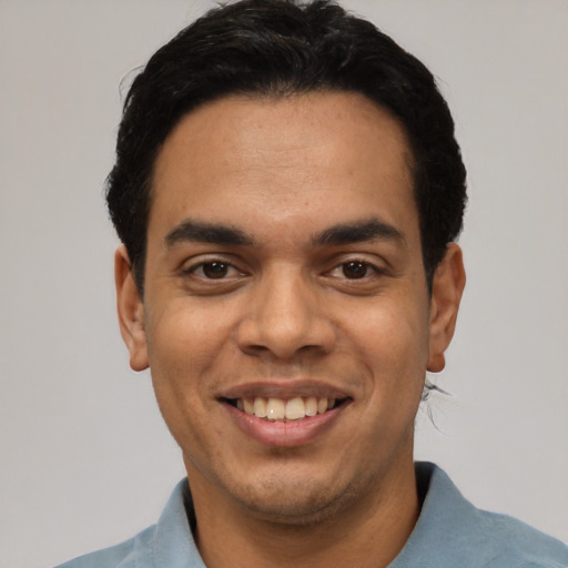 Joyful latino young-adult male with short  black hair and brown eyes