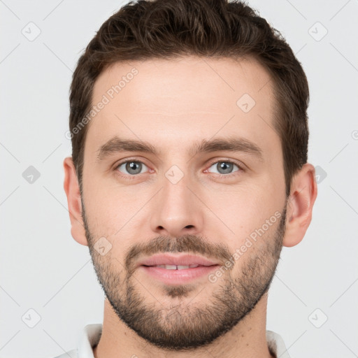 Joyful white young-adult male with short  brown hair and grey eyes