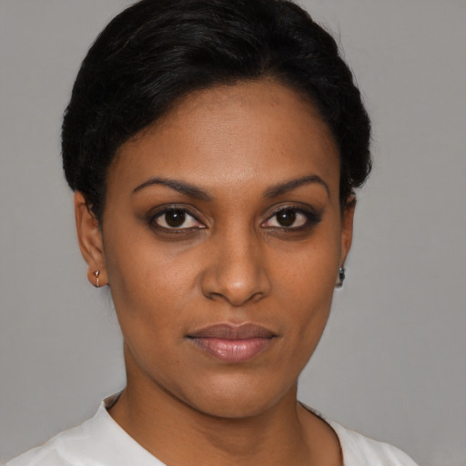 Joyful black young-adult female with short  black hair and brown eyes