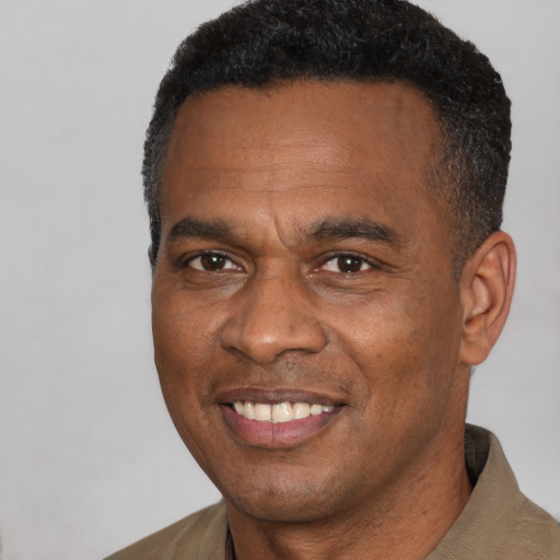 Joyful black adult male with short  black hair and brown eyes