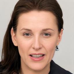 Joyful white adult female with long  brown hair and grey eyes