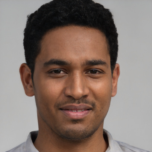 Joyful black young-adult male with short  black hair and brown eyes