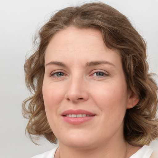 Joyful white young-adult female with medium  brown hair and blue eyes