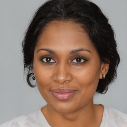 Joyful black adult female with medium  brown hair and brown eyes