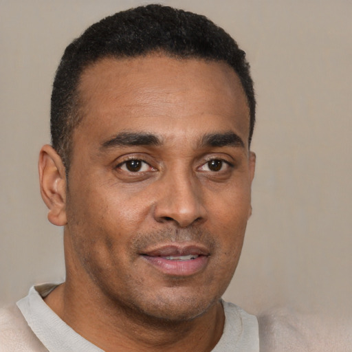 Joyful black young-adult male with short  brown hair and brown eyes