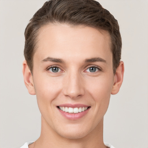 Joyful white young-adult male with short  brown hair and grey eyes