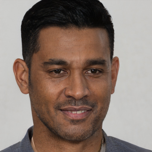 Joyful black adult male with short  black hair and brown eyes