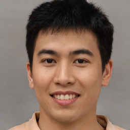 Joyful asian young-adult male with short  brown hair and brown eyes