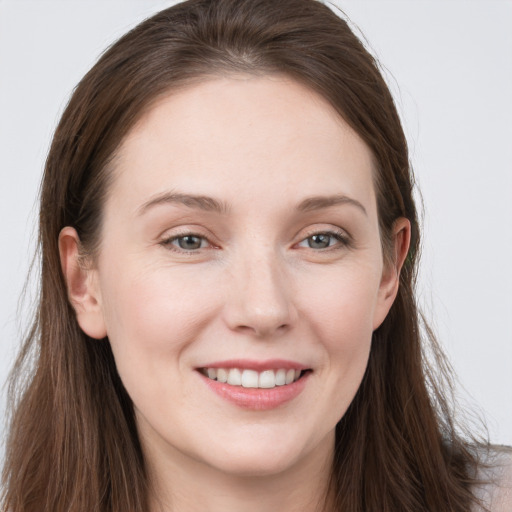 Joyful white young-adult female with long  brown hair and grey eyes