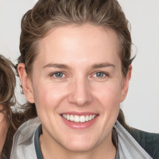 Joyful white adult female with medium  brown hair and grey eyes