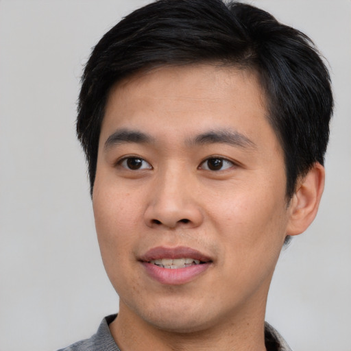 Joyful asian young-adult male with short  brown hair and brown eyes