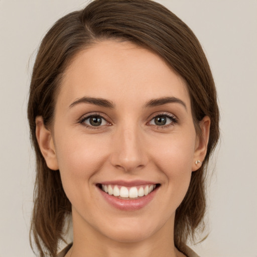 Joyful white young-adult female with medium  brown hair and green eyes