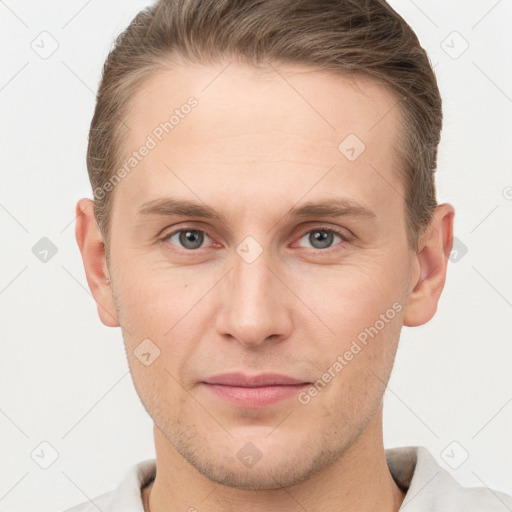 Joyful white young-adult male with short  brown hair and grey eyes