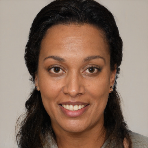 Joyful black adult female with medium  brown hair and brown eyes