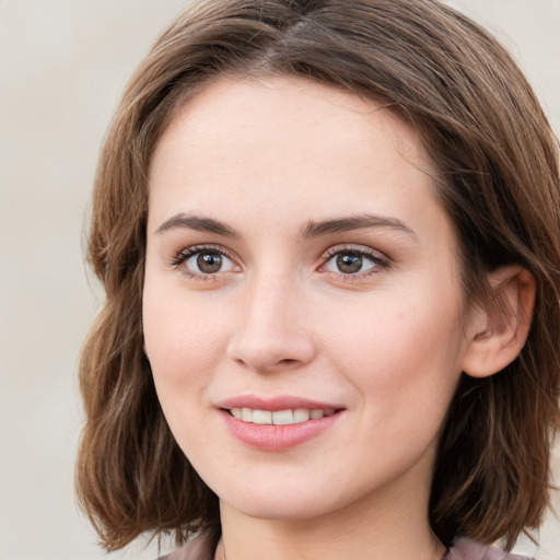 Joyful white young-adult female with medium  brown hair and green eyes